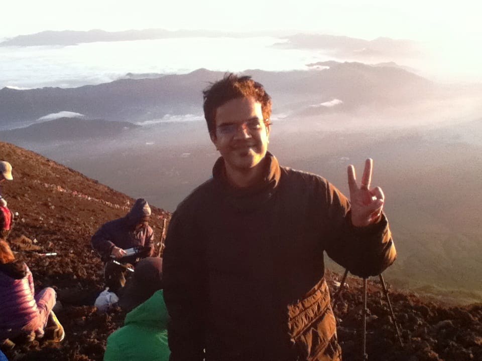 Amit Kumar Soni at sunrise on a misty mountain summit during his time in Japan.
