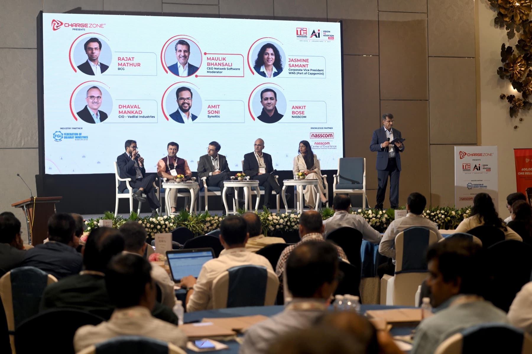 Amit Kumar Soni on a panel of five speakers in front of a large event screen.