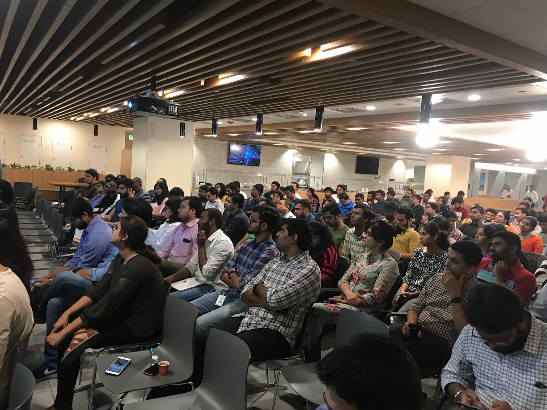 A full room of professionals listening to a session.