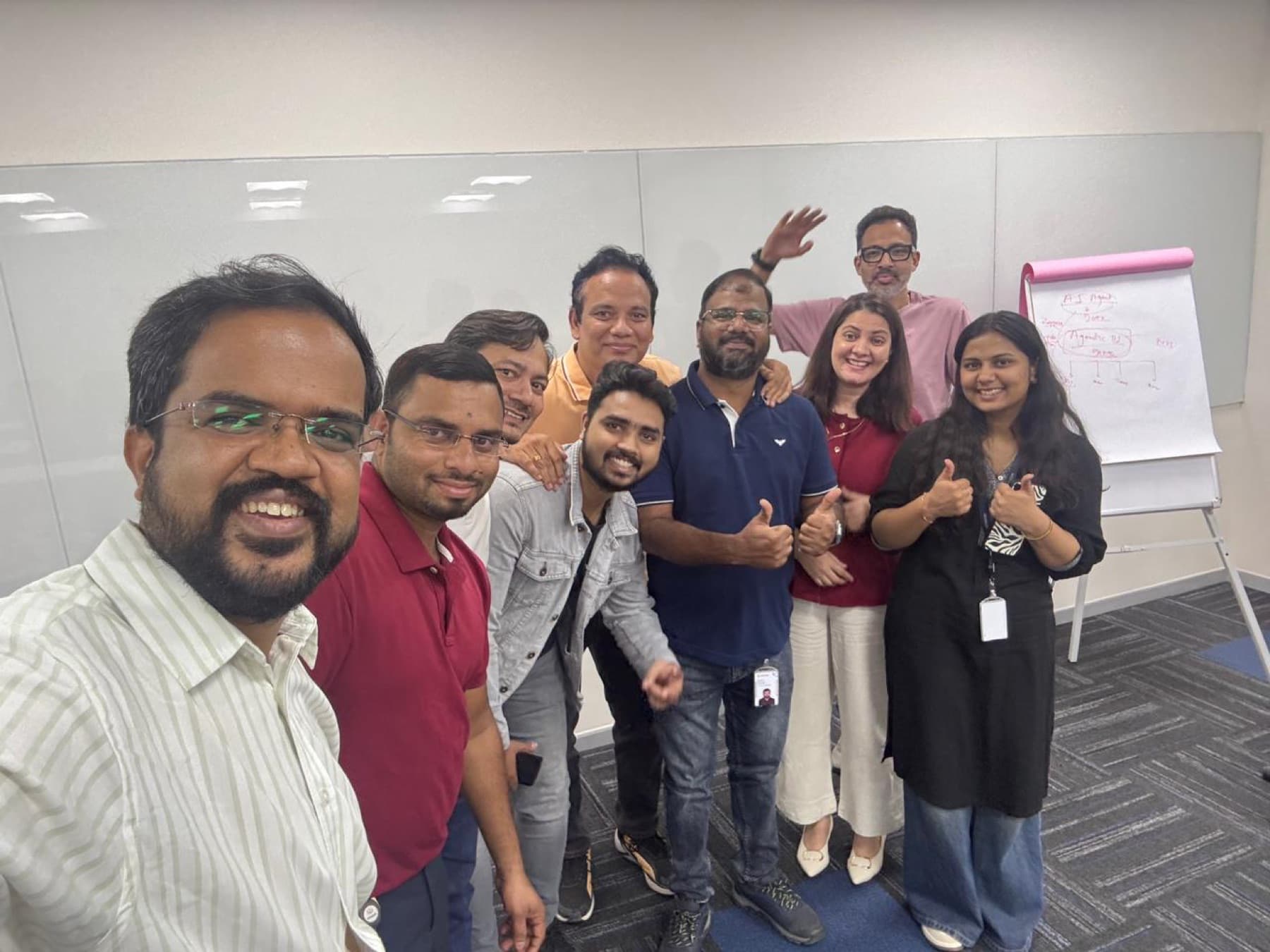 A workshop team smiling in a selfie with thumbs up.