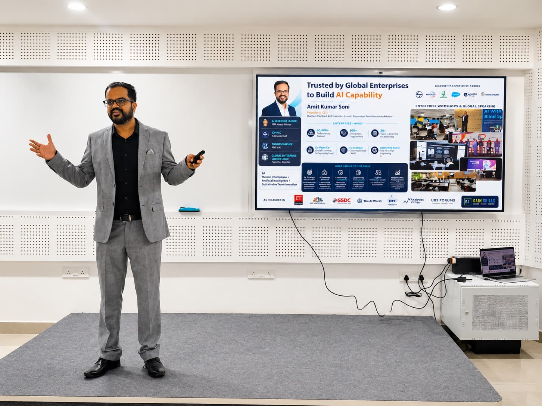 Amit Kumar Soni presenting in a grey suit beside a screen on building AI capability.