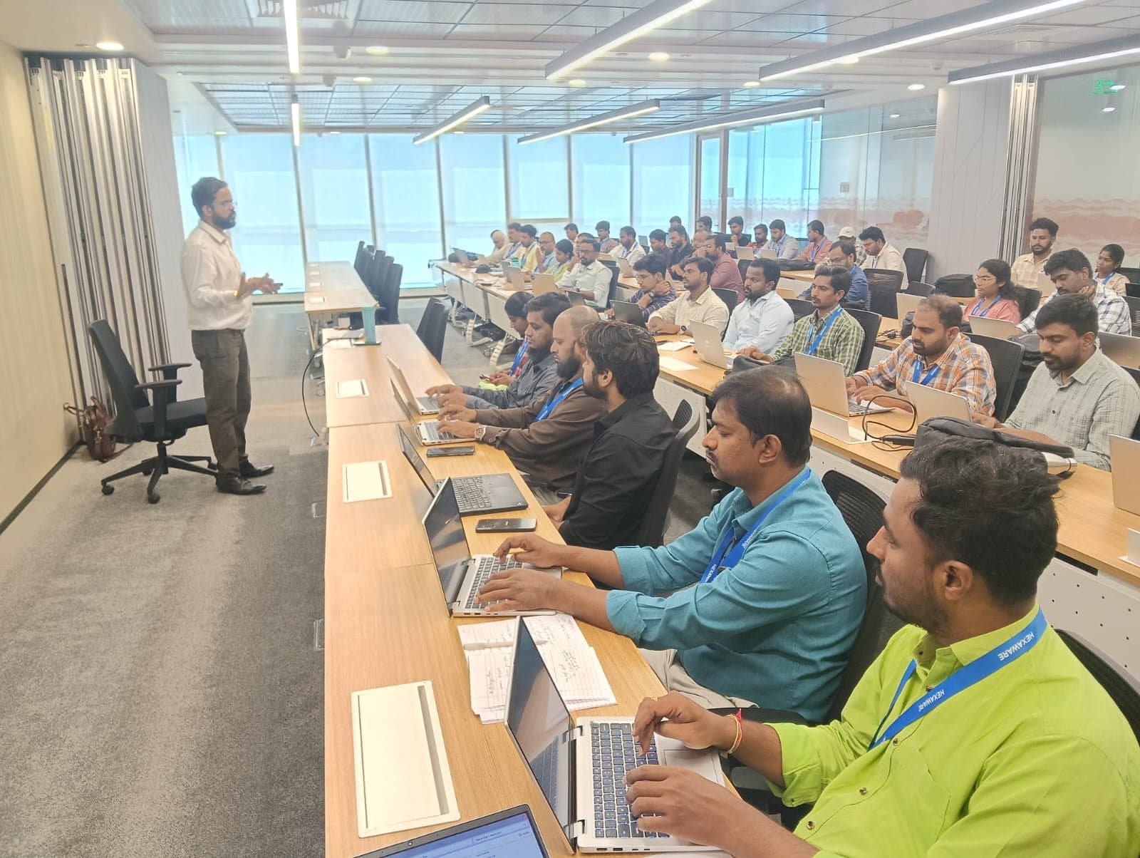 Amit Kumar Soni teaching a room of professionals working at laptops.